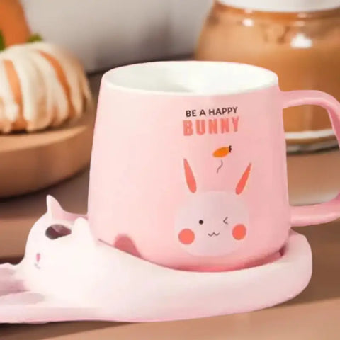 Taza rosa con plato a juego y calentador de taza en forma de perro y gato