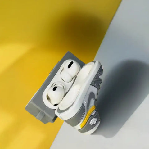 Estuche para AirPods con forma de zapatilla en color gris y blanco.