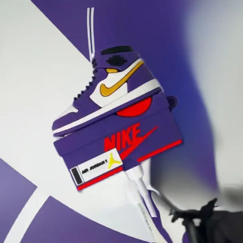 estuche morado y dorado con forma de zapatillas air jordan.