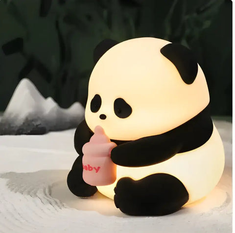 luz nocturna de panda iluminada sosteniendo un biberón.