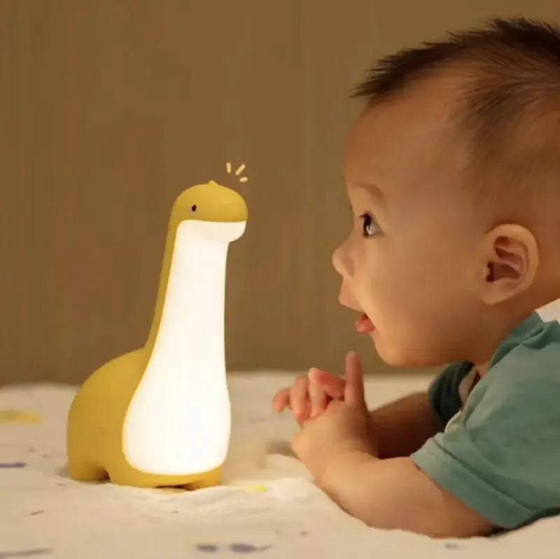Lámpara nocturna en forma de dinosaurio amarillo y niño