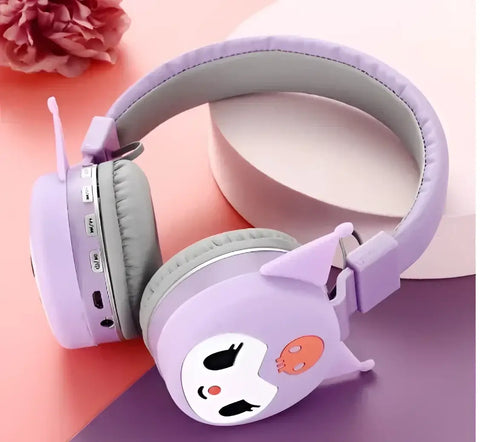 Auriculares Bluetooth Kuromi morados en primer plano apoyados de lado sobre superficie clara.