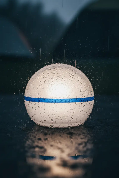 Lámpara LED de camping resistente al agua en exterior, con ambiente nocturno y humedad/lluvia.
