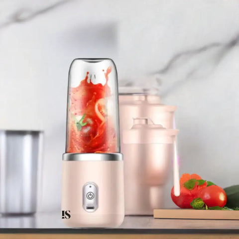 Licuadora portátil rosa con contenido rojo, ideal para preparar batidos saludables