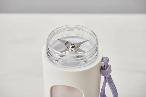 Vista superior de la batidora portátil mostrando la tapa y las cuchillas de acero inoxidable