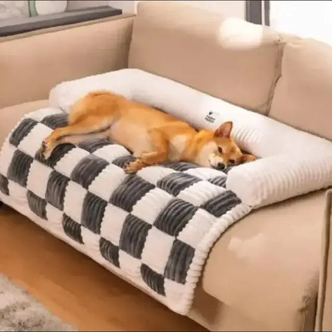 Shiba Inu dormido en una funda para sofá antimanchas para mascotas sobre manta a cuadros